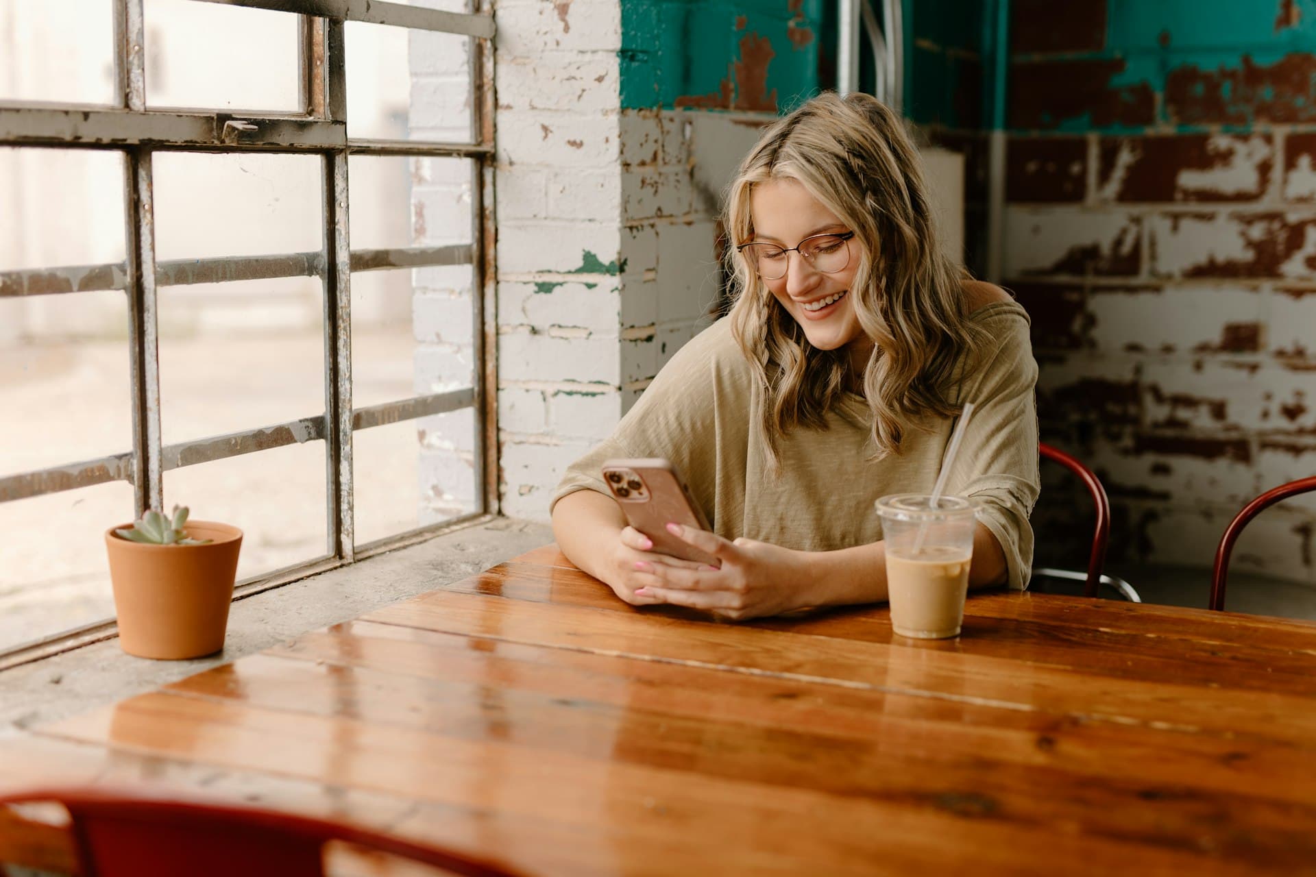 Cliente consultant les avis Google d'un établissement sur son smartphone dans un café
